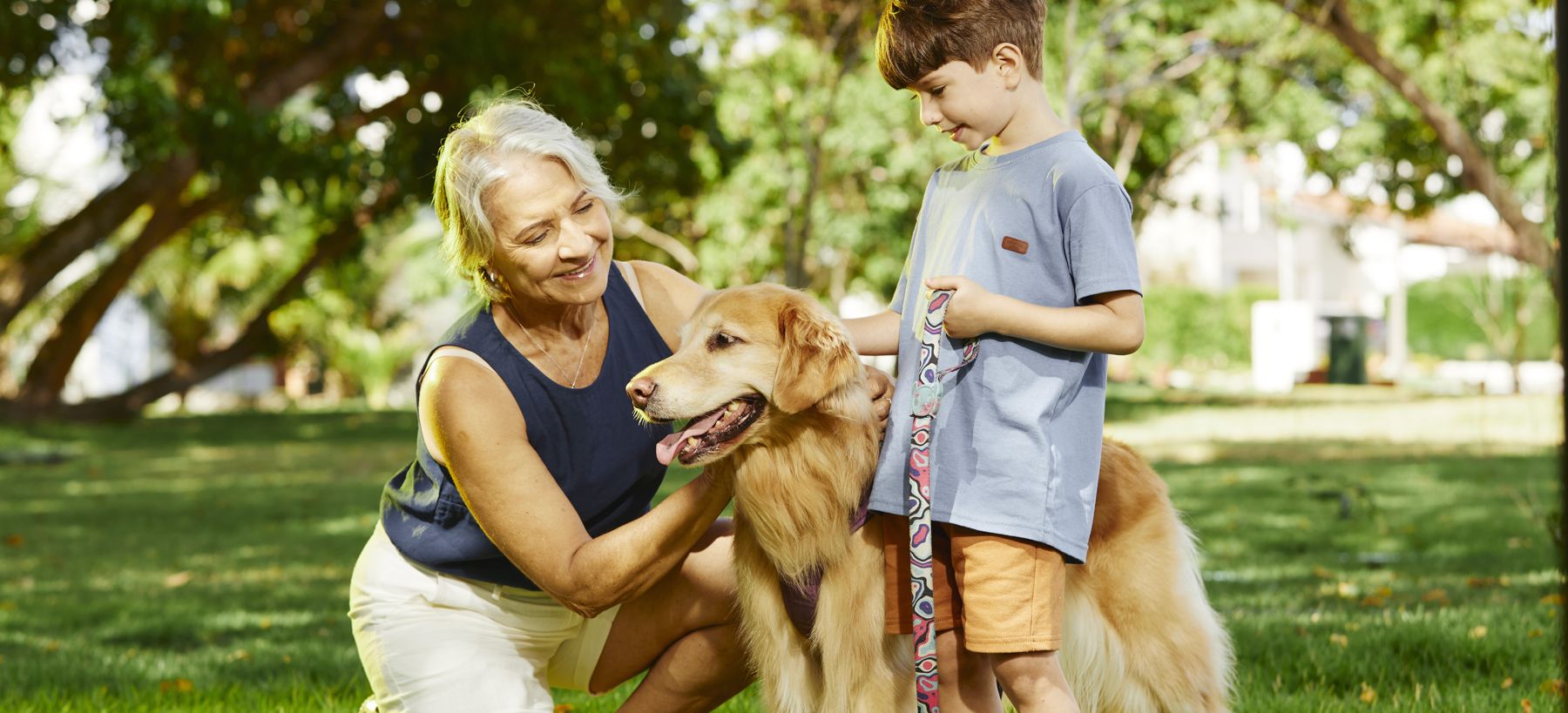 Avó, neto e cachorro no jardim