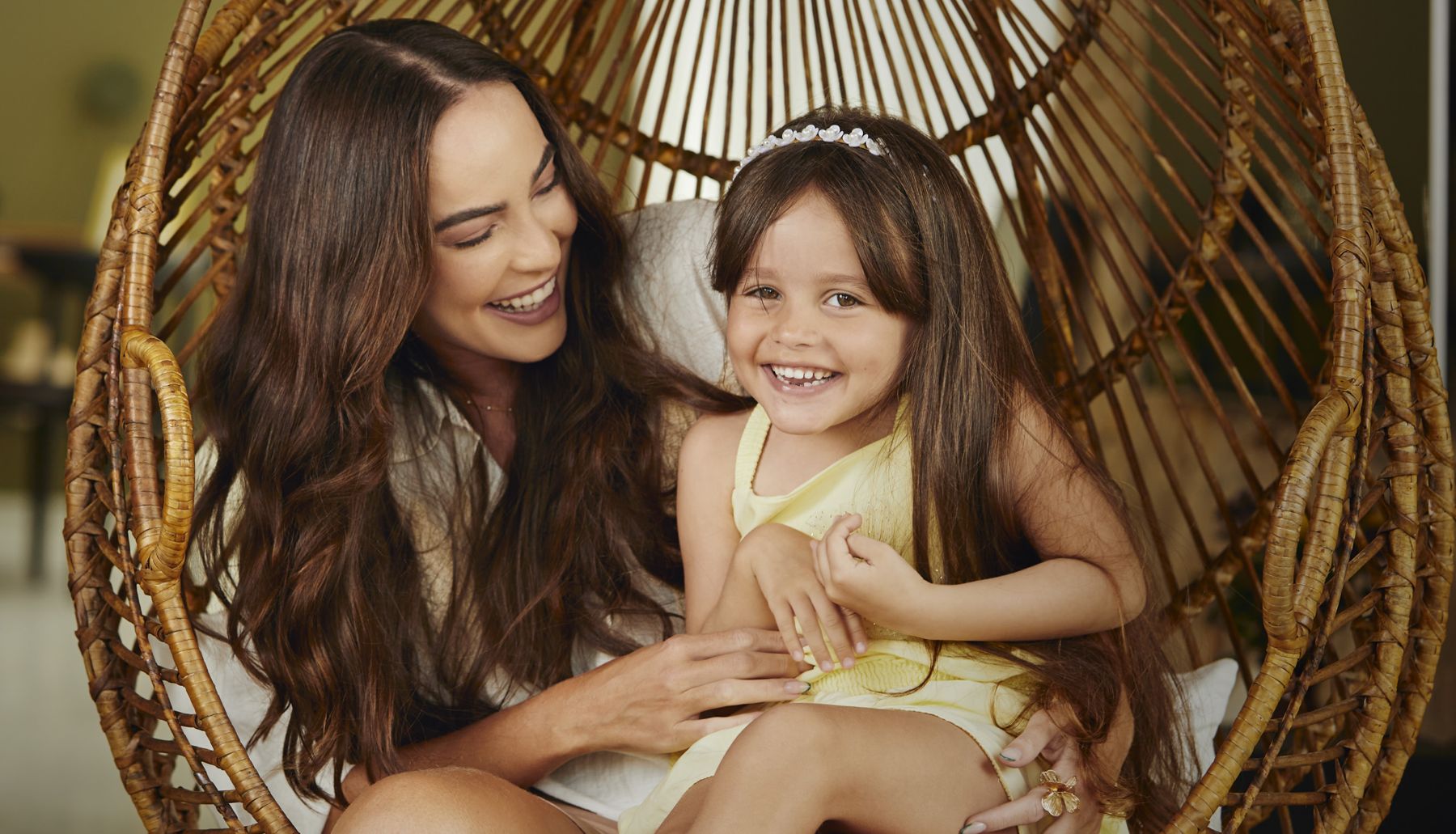 Mãe e filha na cadeira de vime